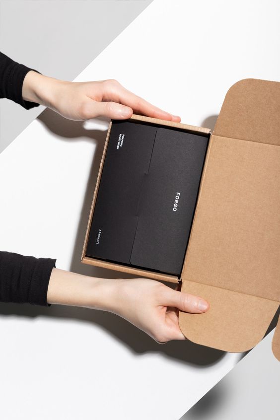 A woman's hands box a beautifully-packaged item for shipping.